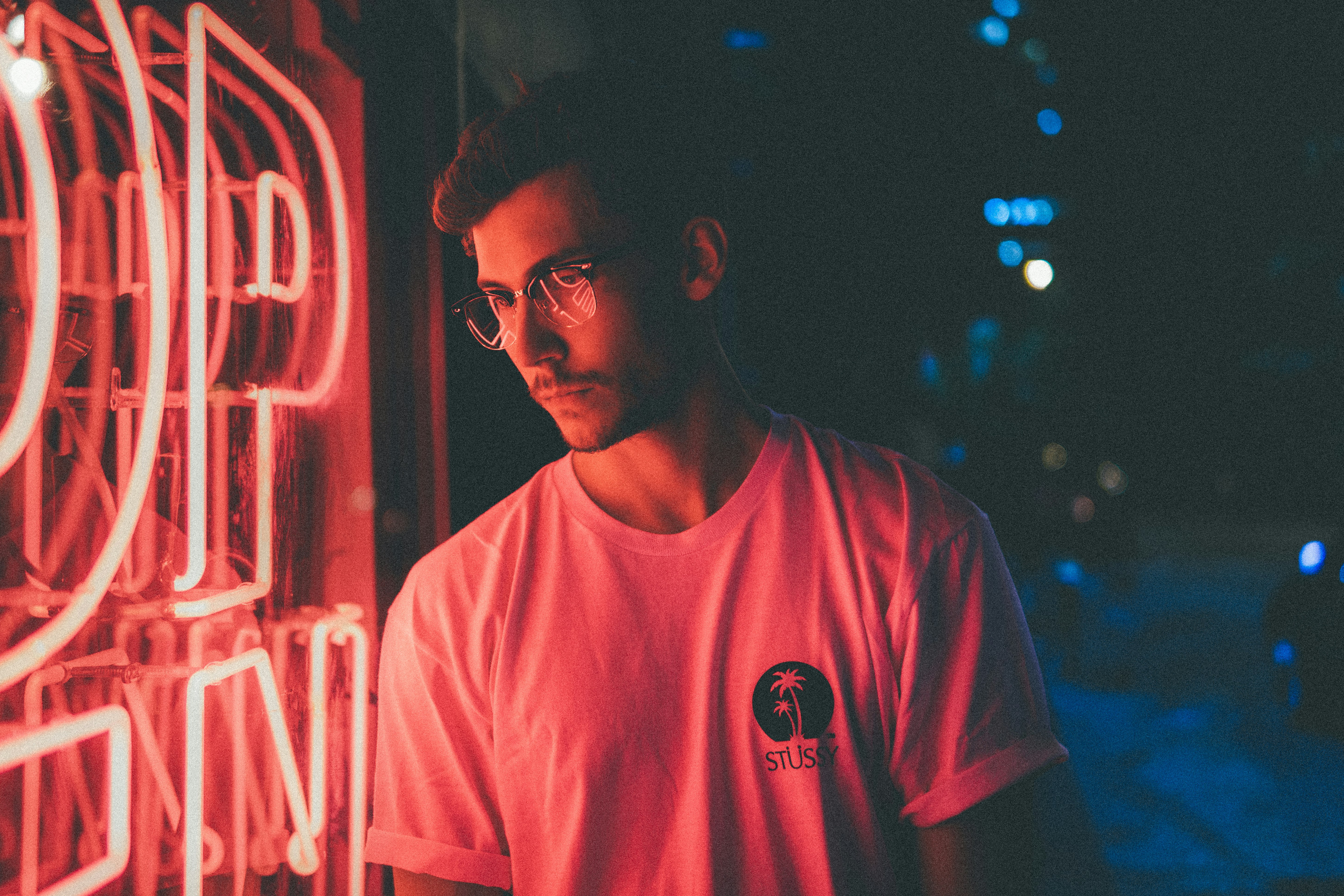 man standing in front of pink neon light signage